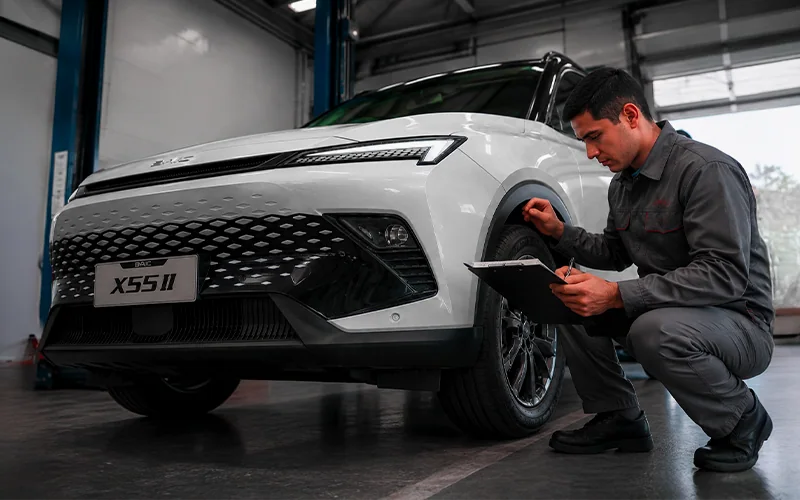 Técnico revisando el tren delantero de un BAIC X55 en el taller