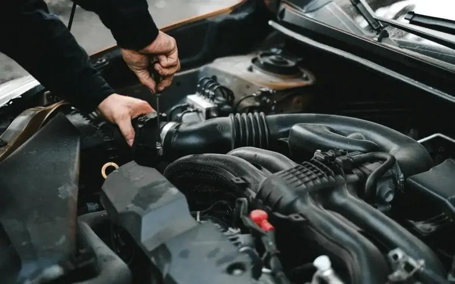 Técnico de la red BAIC trabajando sobre el motor de un vehículo